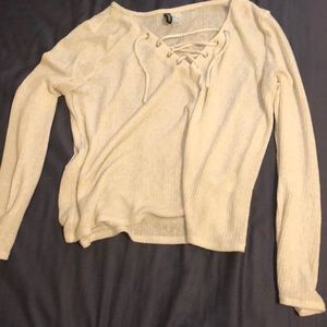 White loose top. Long sleeved with a lace up neck